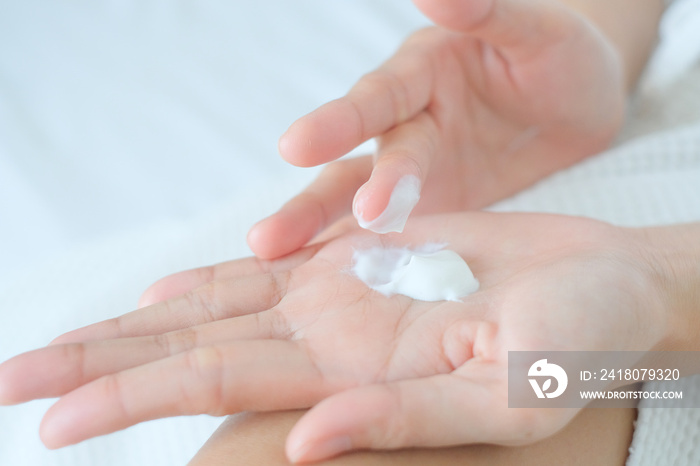 Woman applying moisturizing cream/lotion on hands, beauty concept.