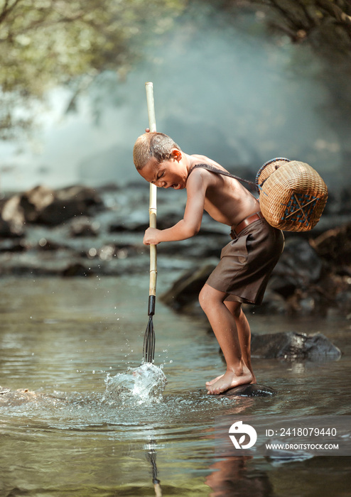 小男孩在泰国农村家附近的溪流中钓鱼