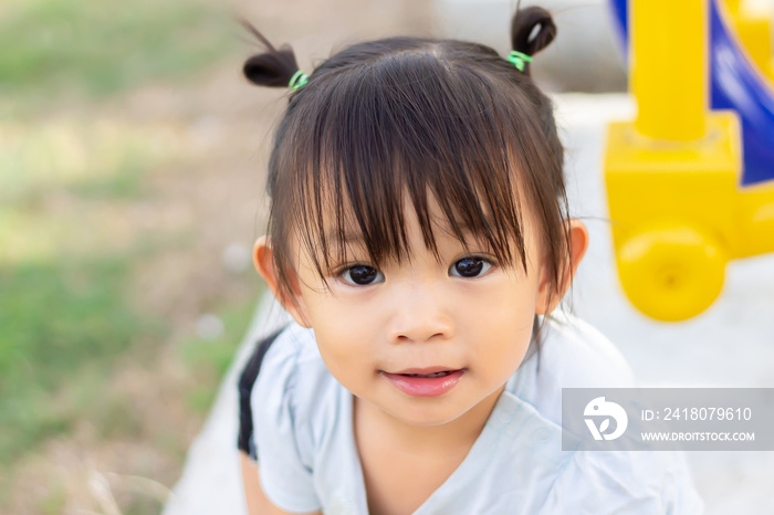 Portrait image of 1-2 years old baby. Happy Asian child girl smiling and relaxing at the garden park