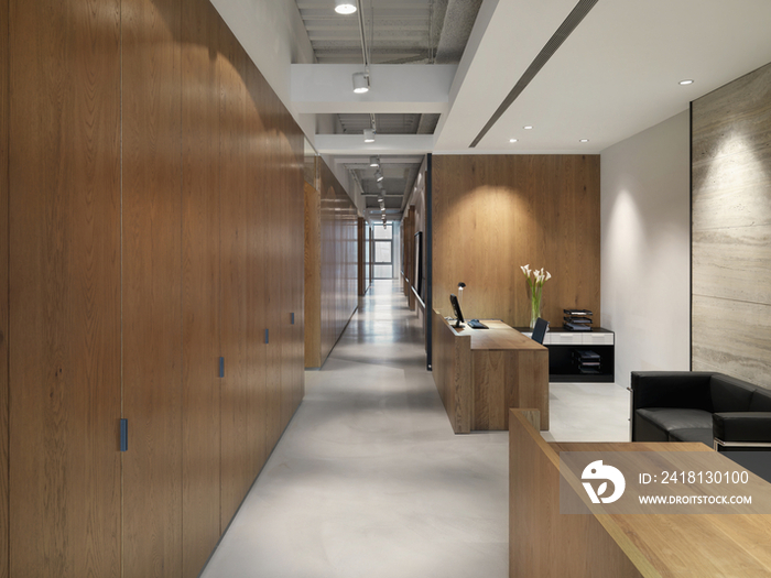 Empty hallway by reception area in office