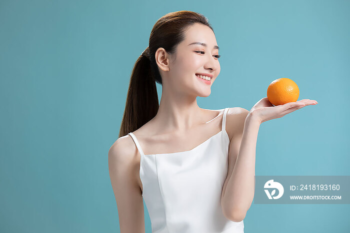 年轻美女拿着橙子
