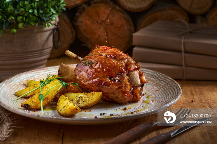 猪肉节和烤土豆放在乡村厨房桌子上，深色木质背景，前视。猪肉