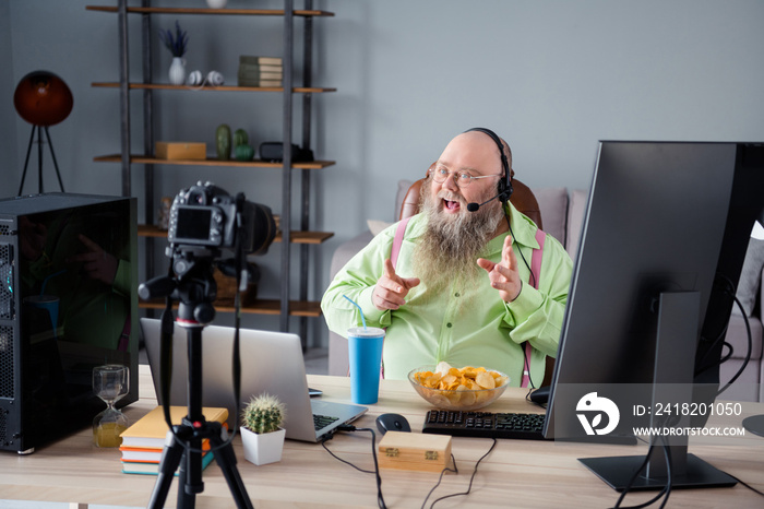 Photo of happy man blogger look camera talk formalwear eat junk food wear headphones indoors inside 