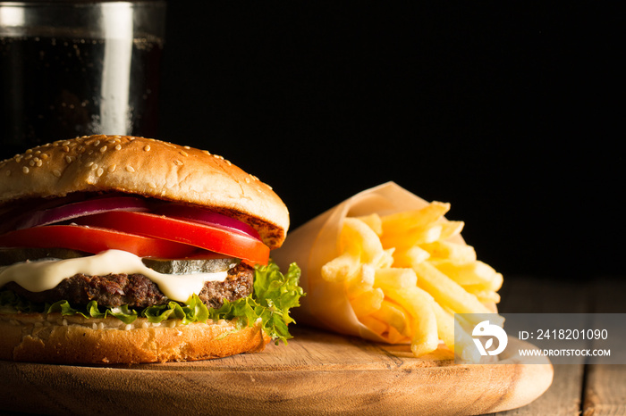 Home made hamburger with beef, onion, tomato, lettuce and cheese. Fresh burger close up on wooden ru