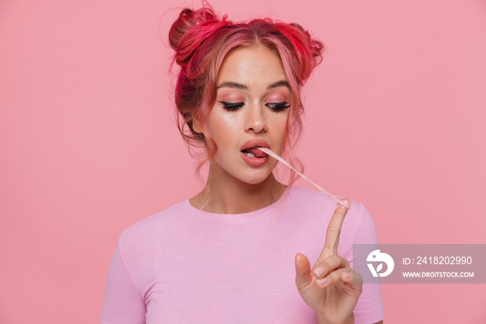 Portrait of glamorous young woman with colored hair stretching chewing gum