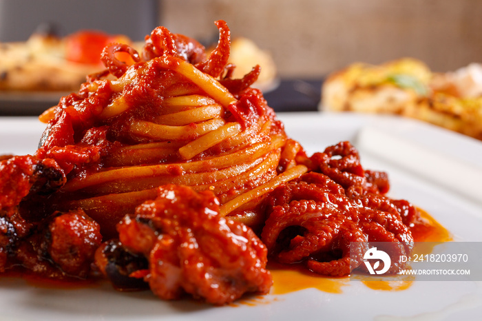 Spaghetti con sugo di polipetti serviti come primo piatto in un ristorante