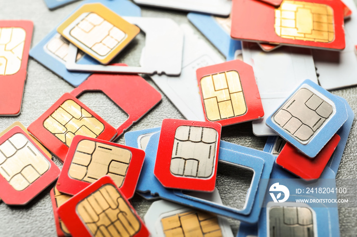 Many sim cards on grey background, closeup