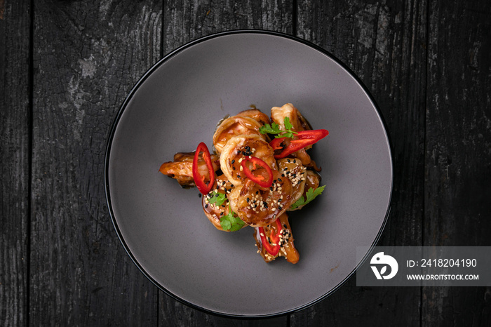 Seafood in a gray plate on a dark wooden table