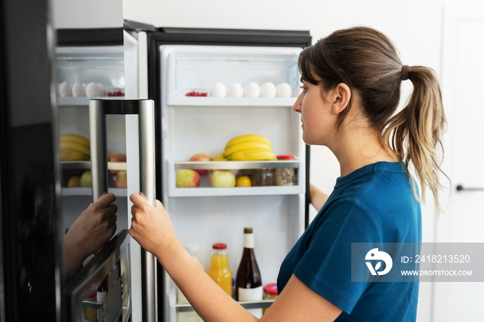 健康饮食、食物和饮食理念——女性在家庭厨房打开冰箱