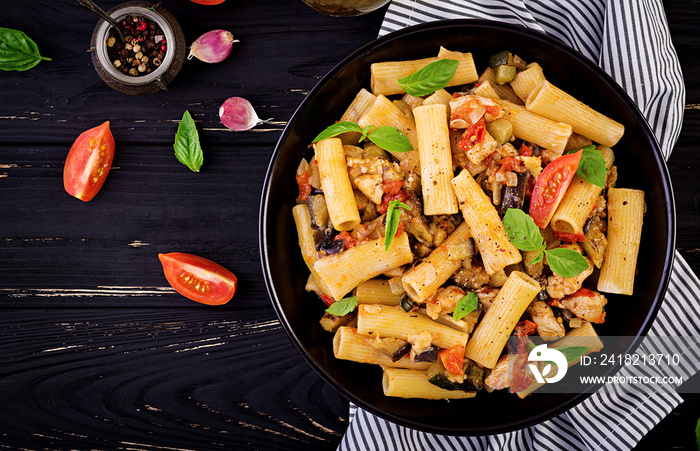 Rigatoni pasta with chicken meat, eggplant in tomato sauce in bowl. Italian cuisine. Top view. Copy 