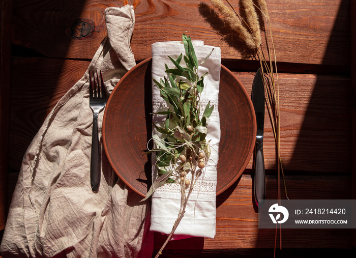 空的手工粘土盘子，桌布上有叉子。桌子上放着手工制作的盘子——自然