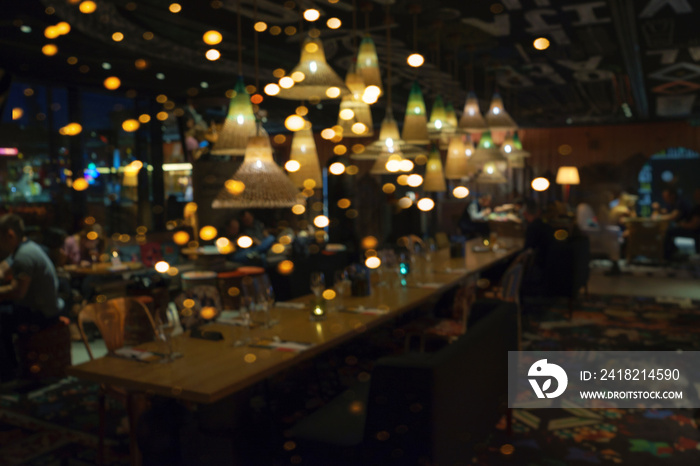 Blurred background of people sitting at restaurant, bar or night club with colorful lights bokeh.