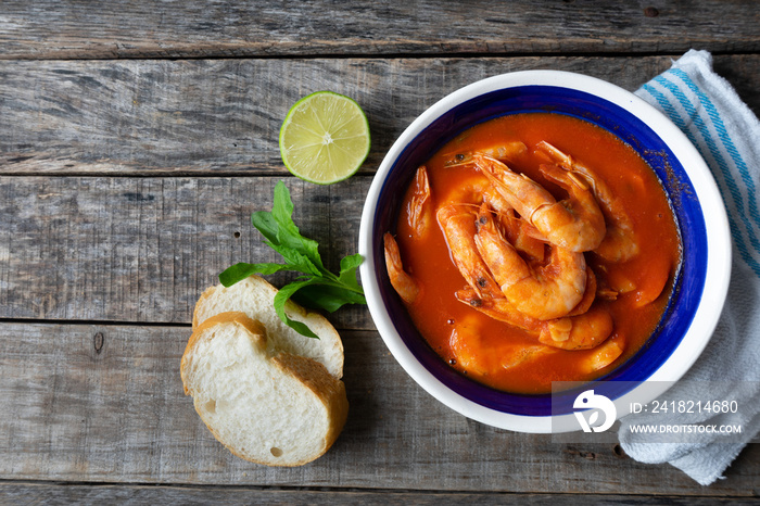 Mexican shrimp soup on wooden background