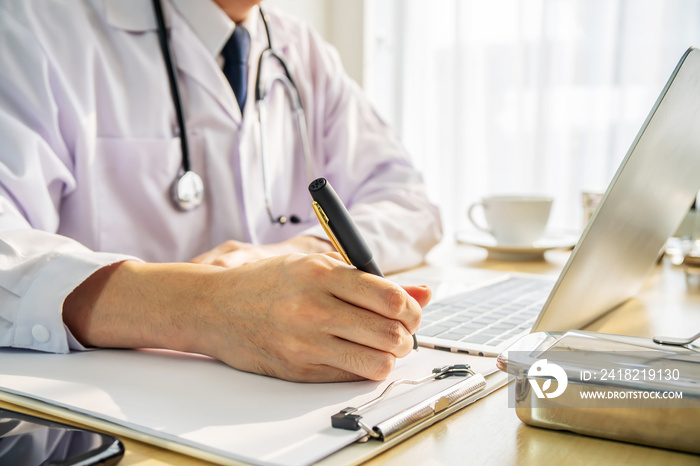 Side view cropped shot of male doctor in white uniform with stethoscope on neck at paperwork with no