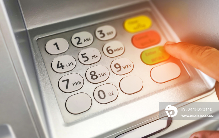 Close-up of hand entering on ATM/bank machine keypad.