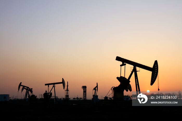 the oil pump in the evening, the evening silhouette of the pumping unit, the silhouette of the oil p