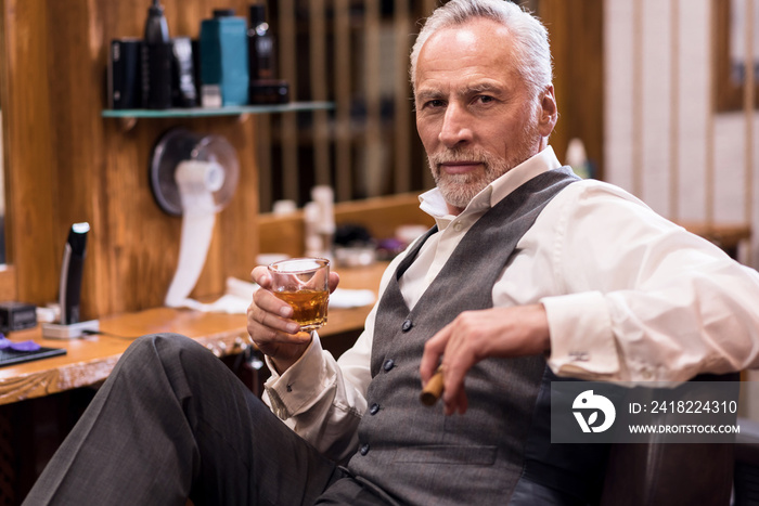 Man sitting with cognac glass and cigar