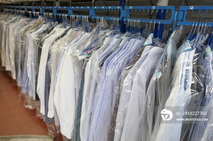 Freshly cleaned mens shirts and ladies blouses  in a textile cleaning, hanging on hangers and packe