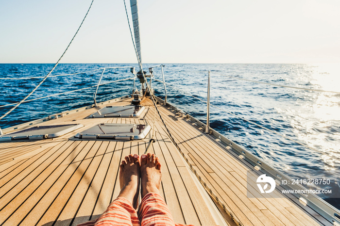 Close up of tourist woman caucasian feet lay down and relaxing enjoying a sail boat trip with ocean 