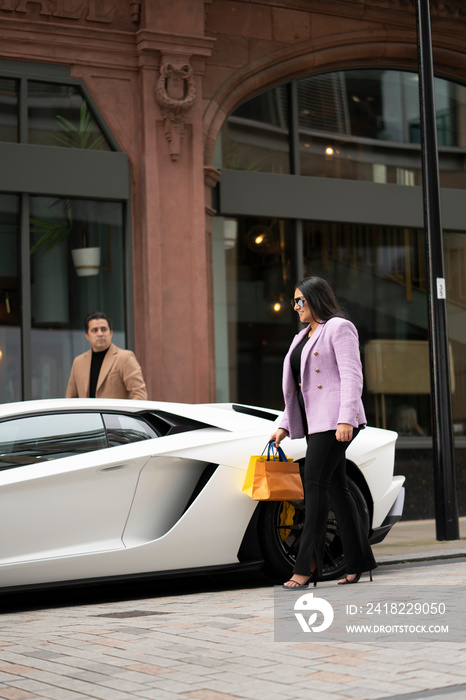 Father and adult daughter getting in luxury car