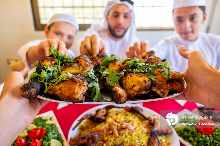 阿拉伯穆斯林家庭正在为他们从盘子里挑选鸡肉
