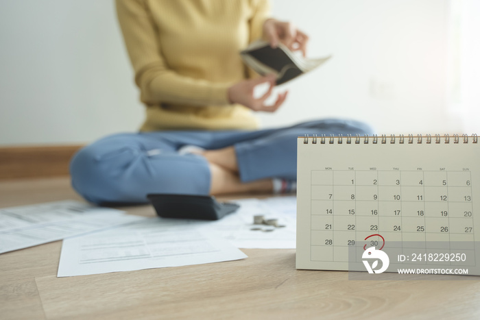 The stressed person sitting on the floor opening empty wallet