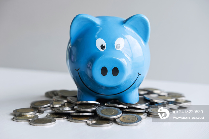 Images of stacking coins pile and blue smiling piggy bank to growing and savings with money box, Sav