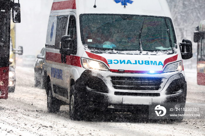 911 ambulance van rushing through traffic during heavy winter snowfall conditions.