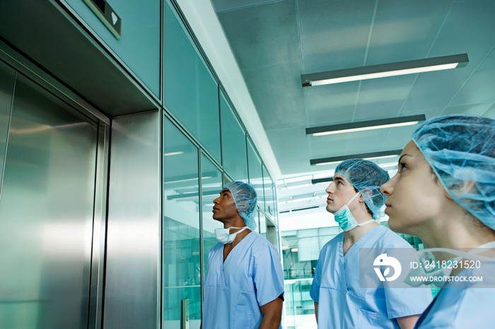 Three surgeons waiting for hospital elevator