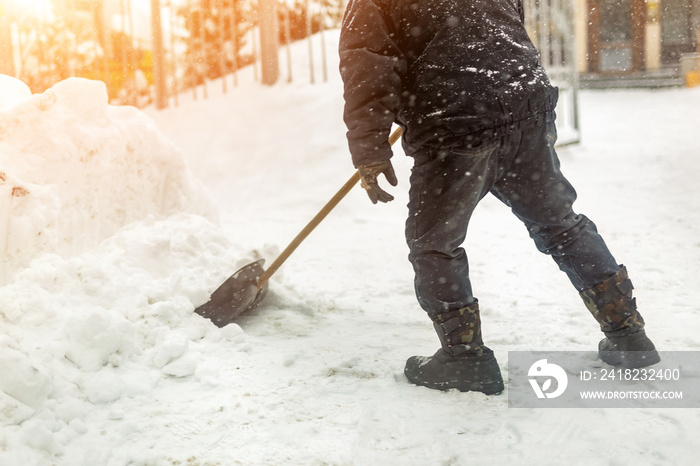 Man removing snow from sidewalk after heavy snowfall. Snowstorm and blizzard aftermath in winter. Sl