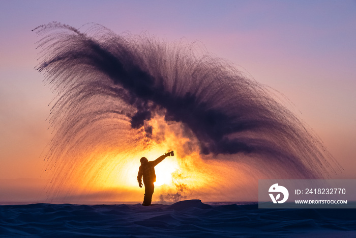 一名身穿冬装的男子将一壶沸水抛向空中，造成快速结冰