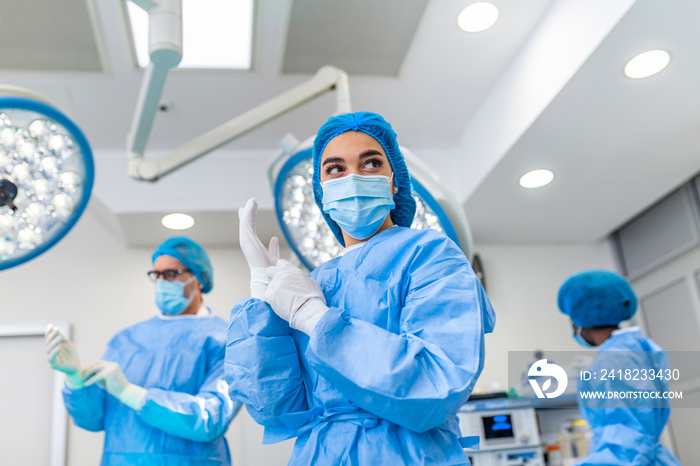 手术室里穿着手术服的女外科医生的画像。穿着磨砂膏的医生