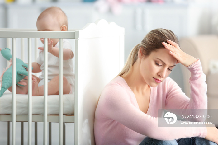 Depressed young woman with cute baby at home