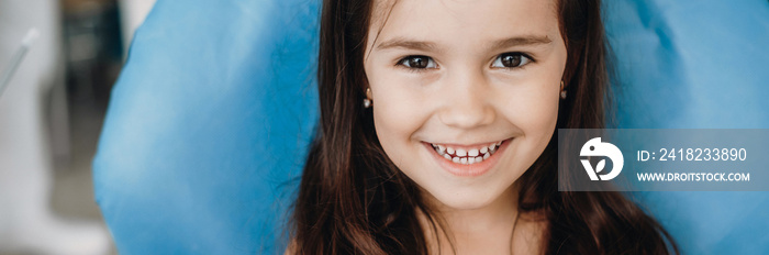 Happy caucasian small girl looking and smiling at camera after a dental surgery