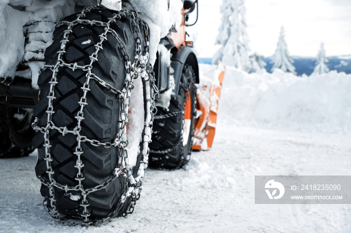 Car wheels equipped with snow chains. Winter season.