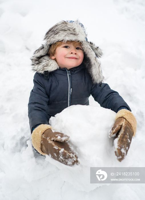 Snowman and funny child the friend is standing in winter hat and scarf with red nose. Joyful kid Hav