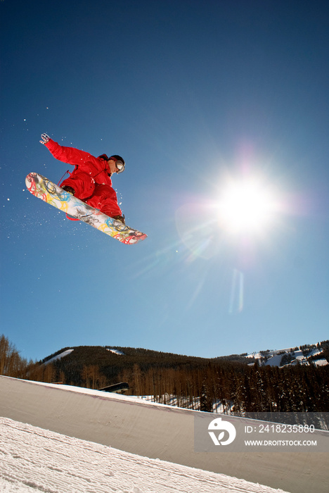 Low angle view of man skateboarding on snow field against clear sky
