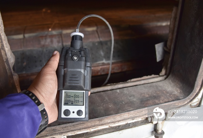 ็ีhuman holding the equipment.Using the gas detector for detect combustible gas , flammable gas , to