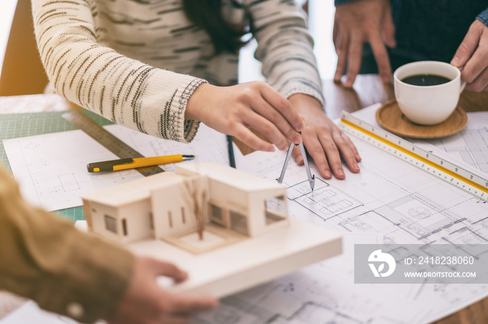 An architect using compass to draw and measure shop drawing in office