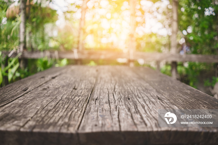 Blur green nature bokeh with sun light on copy space empty old wood table abstract background.