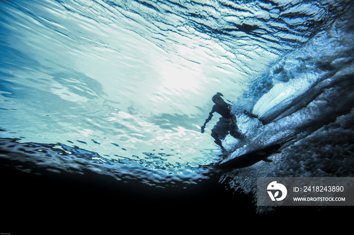 Underwater view of surfer riding wave