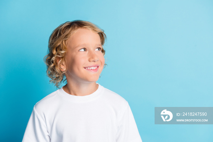 Photo of toothy smiling boy look empty space wear white t-shirt isolated over blue color background