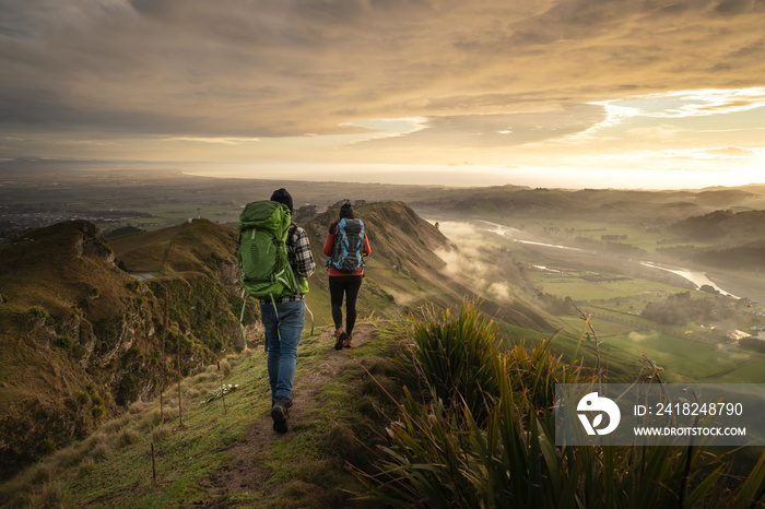 Backpackers walking on a mountain at sunrise. Travel concept