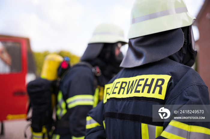 Symbolbild Feuerwehr mit Feuerwehrmann vor einem Feuerwehrauto