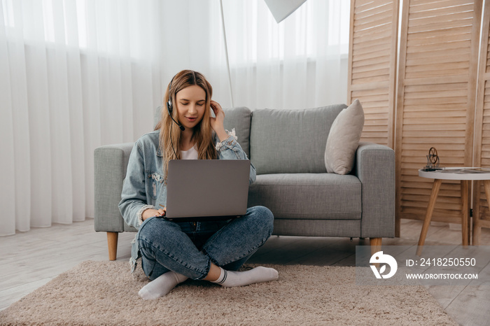 Smiling young teenage girl wear headphones video calling on laptop. Happy woman looking at computer 