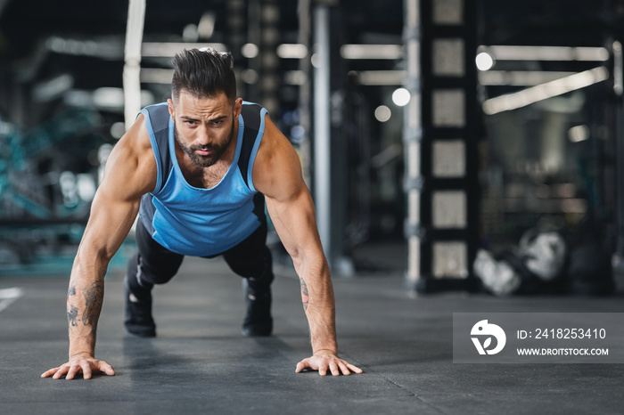 Concentrated muscular guy doing push up exercises