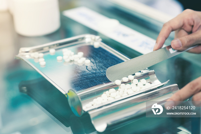 Medicine tablets on counting tray with counting spatula at pharmacy