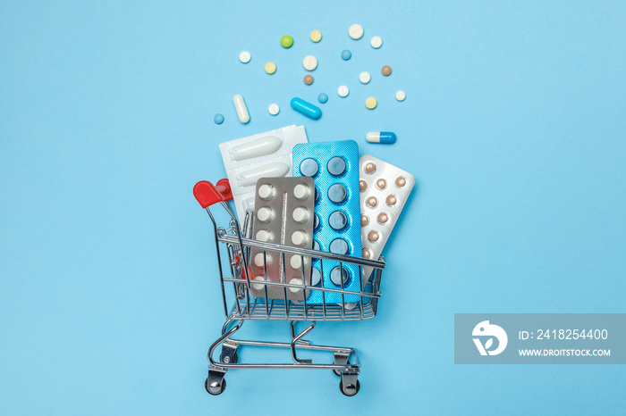 Shopping basket and pills in blisters. The concept of buying drugs online, delivery of medical devic