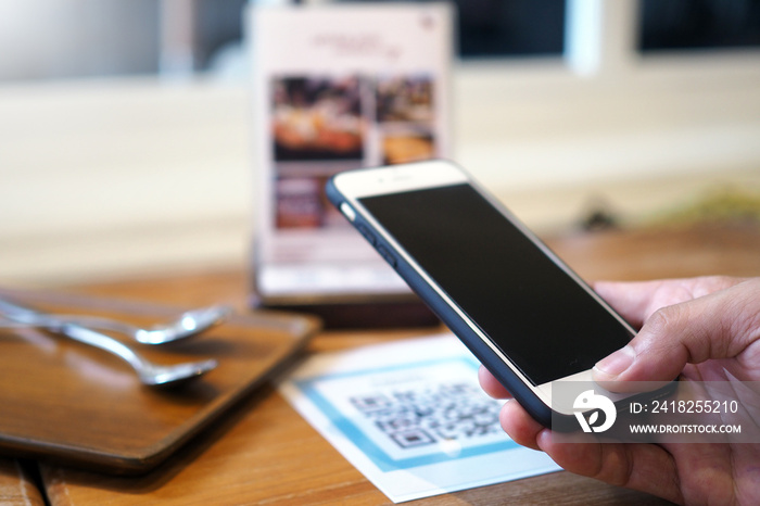 Hands use the phone to scan QR codes to accumulate points in restaurants.