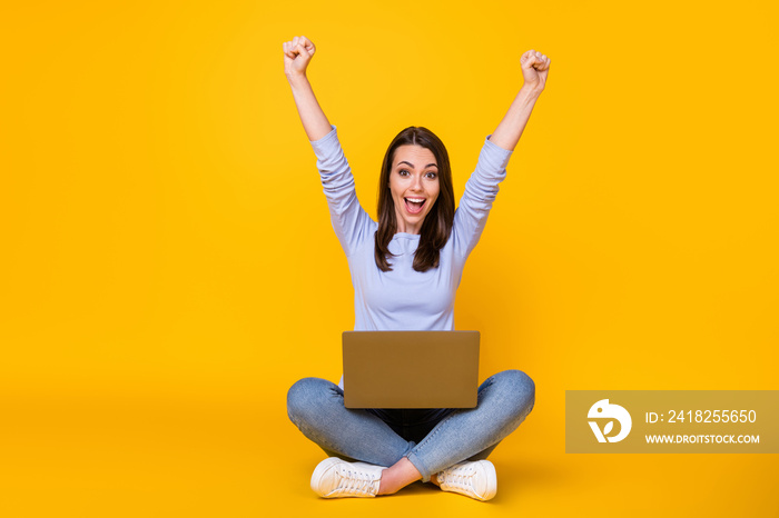 Full length photo of crazy ecstatic girl sit floor legs crossed work remote laptop raise fists screa